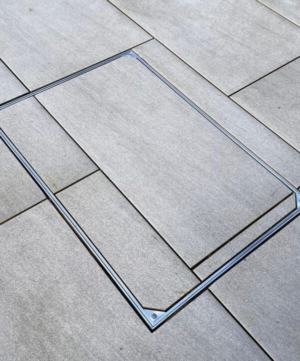 Alusthetic double sealed manhole cover installed outdoors with tile slab infill