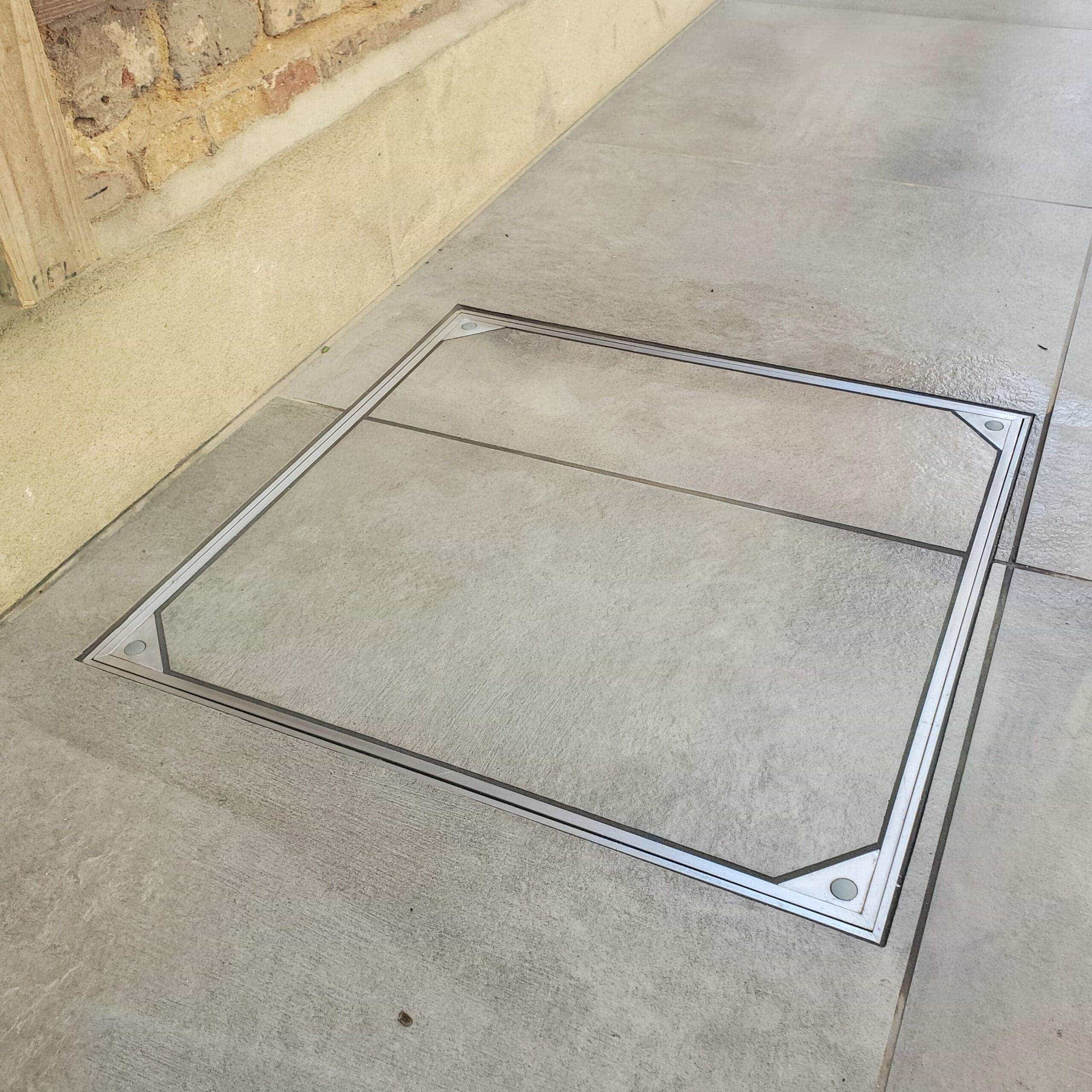 Alusthetic double sealed manhole cover installed outdoors with tile slab infill