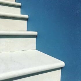 White coloured stone steps with a blue wall